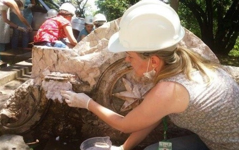 Mulher realizando a limpeza de material histórico